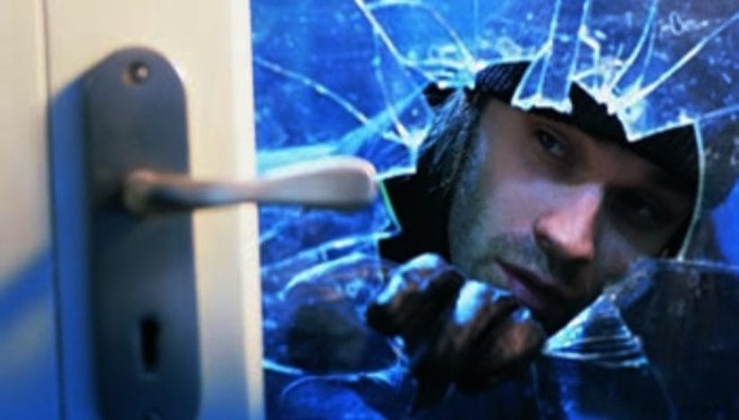 Burglar breaking glass